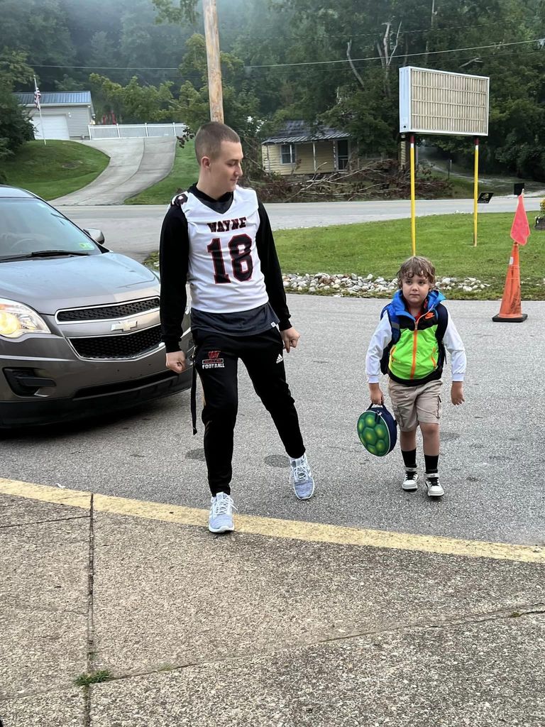 Wayne High School Football Team and Cheerleaders help at elementary school drop off